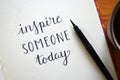 `INSPIRE SOMEONE TODAY` brush calligraphy in notebook