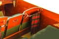 Close-up on interior of classic woodend motorboat with plaid blanket draped on chrome hanger on back of front seat