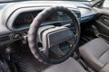 A close-up of the interior of a Russian driverÃ¢â¬â¢s car seat and steering wheel made of plastic and a control panel with