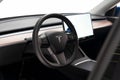 Close-up of an interior Tesla dashboard with a sleek, modern black and tan design