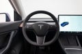 Close-up of an interior Tesla dashboard with a sleek, modern black and tan design