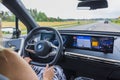 Close up interior view of BMW iX 40 on road. Woman driver in vehicle drives on highway.