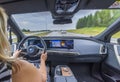 Close up interior view of electric car BMW iX40 on road. Female driver in vehicle.