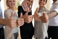 Close up international colleagues hands showing thumbs up gesture. Royalty Free Stock Photo