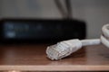 Close up of internet cable on wooden table with modem in the background Royalty Free Stock Photo