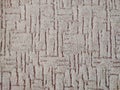 Close-up of an intricately designed, brown textured carpet. Royalty Free Stock Photo