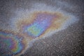 Close-up of an iridescent oil or gasoline spill on a wet asphalt, viewed from above. Bold multicolored spots on the Royalty Free Stock Photo