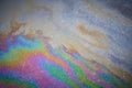 Close-up of an iridescent oil or gasoline spill on a wet asphalt, viewed from above. Royalty Free Stock Photo