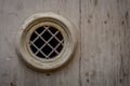 Close up of a ironwork peephole on a medieval wooden door.