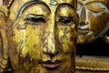 Close up of isolated ancient gold paint wood Buddha head face of thai statue in buddhist temple Royalty Free Stock Photo