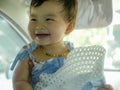 Close up isolated face portrait of sweet and adorable Asian Korean baby girl laughing and smiling cheerful holding hat enjoying Royalty Free Stock Photo