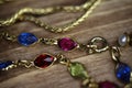 Close up isolated group gold precious jewellery chains and colorful gem bracelet on wood table Royalty Free Stock Photo