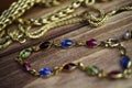 Close up isolated group gold precious jewellery chains and colorful gem bracelet on wood table Royalty Free Stock Photo