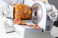 Close up isolated image showing a butcher or chef slicing a large frozen cured meat block