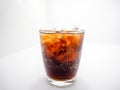 Soft drink and ice in a curved clear glass, white background Royalty Free Stock Photo