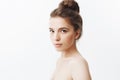 Close up isolated portrait of relaxed beautiful young skinny woman with long dark hair in bun hairstyle, posing half