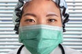 Close up portrait of young attractive and confident Asian Chinese medicine doctor woman in protective head cap face mask Royalty Free Stock Photo