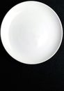 Close up isolated white plate on bkack background Royalty Free Stock Photo