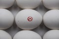 Close up of isolated white raw egg with painting of red smiling face surrounded by group of equal eggs focus on face Royalty Free Stock Photo