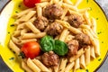 Close-up of Italian pasta with tomato sauce and meatballs on a yellow plate and a gray background. Restaurant menu, dieting, Royalty Free Stock Photo