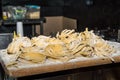 Close up. Italian street food. Freshly prepared tagliatelle are dried on a wooden board. Night city