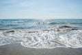 Close up. Italy, Rome, Ostia. Coast of the Tyrrhenian Sea. Seascape. A fine day, blue sky, foamy waves of the azure sea roll