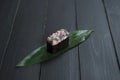 Close up of Japanese Gunkan Maguro Maki Sushi with tuna and tobiko caviar on bamboo leaf on black wooden board Royalty Free Stock Photo