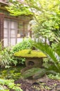 Japanese stone Nozura lantern covered with lichen moss in the backyard of a ryokan guesthouse. Royalty Free Stock Photo