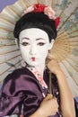 Close-up of Japanese woman with painted face holding parasol Royalty Free Stock Photo