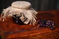 Close-up of a jar of homemade gooseberry jam and ripe fresh berries on a rustic wooden surface. Canning concept