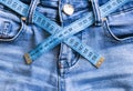 Close up jeans and soft meter waist measurement.