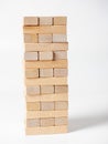 Close-up of a jenga game made of wooden blocks on a white background. Side view