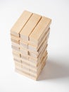 Close-up of a jenga game made of wooden blocks on a white background. Side view