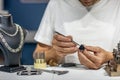 A jeweler in a workshop is working on a ring. Ring in the hands of a jeweler close-up Royalty Free Stock Photo