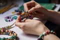 close-up of jewelry designer& x27;s hands, working with beads and thread