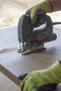 close-up. jigsaw. hands of the employee. they are sawing plywood