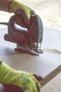 close-up. jigsaw. hands of the employee. they are sawing plywood