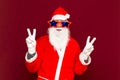 Close up joyful funny playful naughty santa showing peace victory signs, fooling around, in trendy specs, so confident