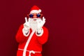 Close up joyful funny playful santa showing peace victory and zero signs, fooling around, in trendy specs, so confident