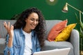 Close-up of joyful woman studying at home, watching video tutorial course, smiling contentedly sitting on sofa in living