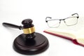 Close up of judge gavel or hammer and blurred glasses on the law book placed behind. Law, judiciary concept. Royalty Free Stock Photo