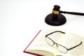 Close up judge gavel or hammer placed behind and blurred glasses with law book. Law, judiciary concept. Royalty Free Stock Photo