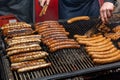 Close-up of juicy bratwurst sausages and meat steaks cooking on grill at German street food market fest Royalty Free Stock Photo