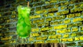 Close-up Juicy cold green lemonade in a glass against the background of a colored brick wall. The cocktail is green Royalty Free Stock Photo