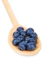 Close-up of a juicy, healthful and tasty blueberry in a wooden spoon, isolated on a white background. Organic heap of berries for