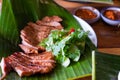 Close up juicy yummy fried sliced pork on green banana leaf , popular traditional Thai food