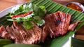 Close up juicy yummy fried sliced pork on green banana leaf , popular traditional Thai food