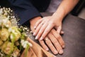 Close up of just married couple holding hands with rings and wedding bunch of flowers Royalty Free Stock Photo