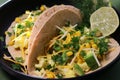 close up of keto tortilla breakfast with scrambled eggs, avocado, cheese and cilantro