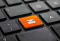 Close-up of a keyboard with an orange email icon key. Email marketing or newsletter concept Royalty Free Stock Photo